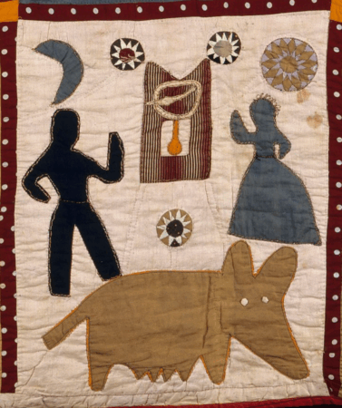 A quilt block with appliquéd figures on a pale background bordered in red with white dots. The design includes a large brown animal with pointed ears, a silhouetted man and woman facing each other, a crescent moon, a striped rectangular shape with a looped cord and drop, and several circular starburst motifs.