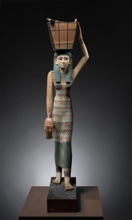 A painted wooden figure of a woman.