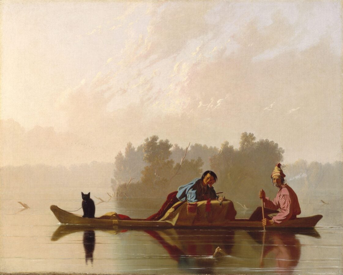 Two traders paddle a long canoe at dusk while a small dark cat sits near the bow.