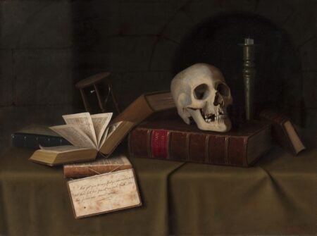 A still life painting in the memento mori tradition, depicting objects symbolizing the passage of time and human mortality. At the center lies a human skull resting atop a large leather-bound book. An hourglass leans in the background, suggesting the inevitability of time running out. An open book with curling pages sits nearby, along with smaller closed books, hinting at knowledge and the transience of learning. A handwritten note lies prominently on a folded document, inscribed with lines reminiscent of a poetic or literary passage. A candlestick with an unlit candle stands in the shadows, reinforcing themes of life’s brevity. The composition is dimly lit, with a dark background, evoking a somber and reflective atmosphere. This artwork, dated 1879, exemplifies the vanitas style, emphasizing the impermanence of earthly pursuits.