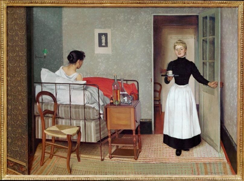 A painting depicting a serene domestic scene. A woman sits upright in a modest metal-framed bed, facing away from the viewer. The room is sparsely furnished, with a bedside table holding bottles and a glass, and a wooden chair nearby. A maid enters through an open door, carrying a tray with a cup, wearing a black blouse and a white apron. The setting conveys a quiet moment of care and recovery, emphasizing simplicity and attentiveness in the late 19th-century environment.