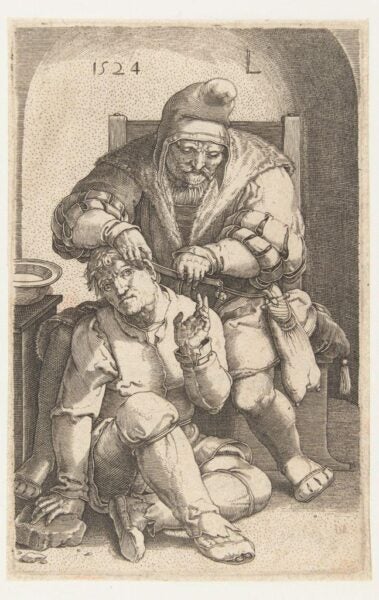 A 16th-century engraving depicting a medieval surgical procedure or a satirical representation of medical practices of the time. The artwork shows an older man, likely a barber-surgeon or healer, wearing a cap and fur-lined clothing, performing a procedure on a seated patient. The patient appears distressed, with a grimace and hand gestures suggesting discomfort. The scene includes modest surroundings, emphasizing the rudimentary nature of early medicine. The year "1524" is inscribed at the top, adding historical context to the image.