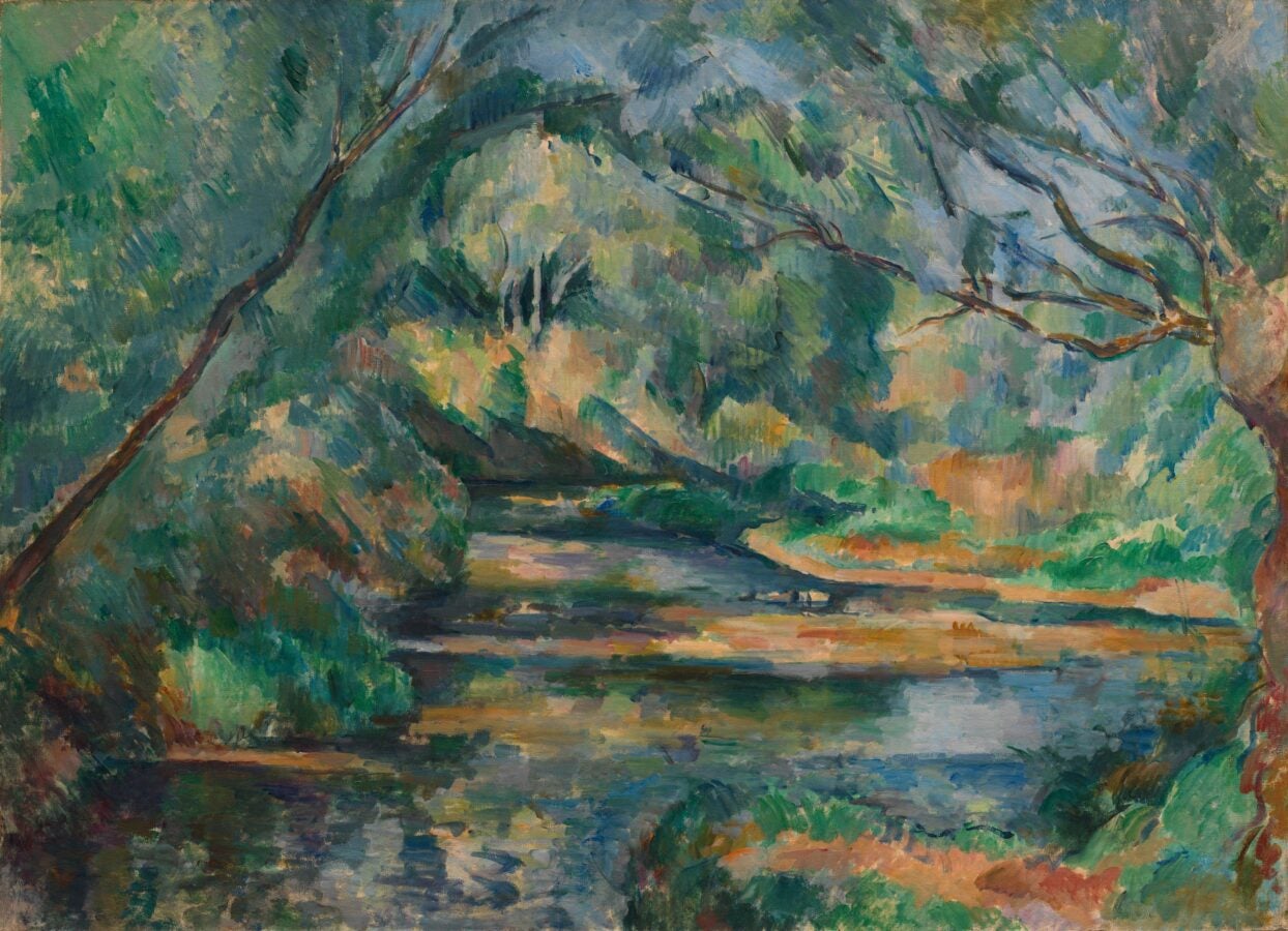 A vibrant, impressionistic landscape painting by Paul Cézanne. The scene features a peaceful brook winding through lush greenery, framed by leaning trees and dense foliage. The reflections of trees and sky shimmer on the water's surface, creating a dynamic interplay of light and shadow with rich, layered hues of green, blue, and earthy tones.