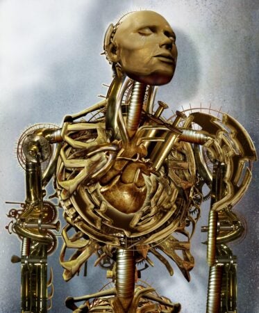A surreal humanoid figure resembling a mechanical cyborg is shown with intricate golden and bronze components. Its face is smooth and expressionless, eyes closed in a serene, meditative pose. The torso is open to reveal a stylized, metallic heart encased in elaborate clockwork and tubing. Gears, pistons, and skeletal arms interlock in a complex design across the figure's chest and shoulders, evoking a fusion of organic anatomy and steampunk machinery. The background is a soft gradient of silver and blue-gray tones.