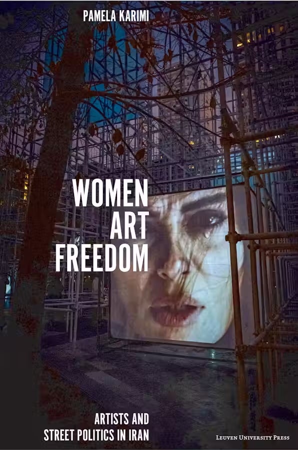 Cover of “Women Art Freedom: Artists and Street Politics in Iran” by Pamela Karimi. The background shows an outdoor urban art installation at night, featuring scaffolding and trees. A large projection of a woman’s face with windblown hair dominates the scene, symbolizing artistic expression and resistance.