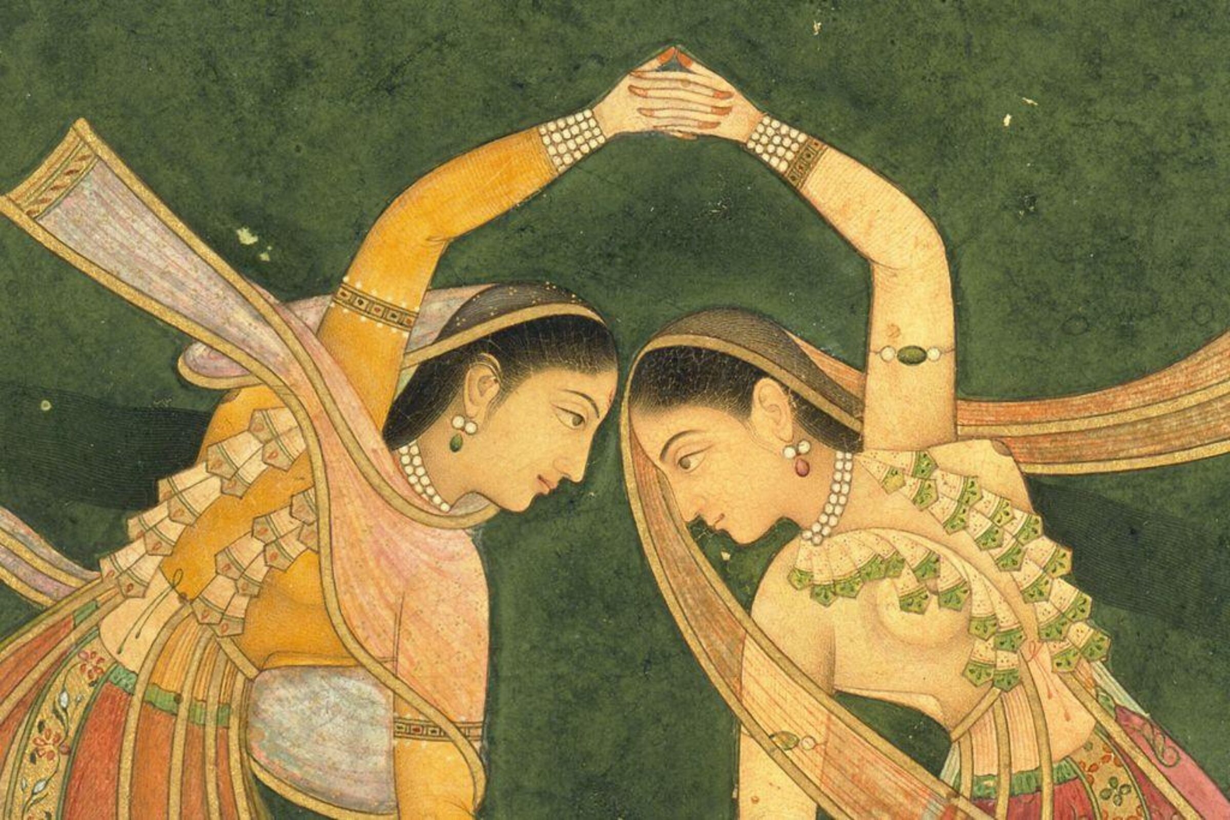 A detailed miniature painting showing two women in flowing, patterned garments and jewelry dancing with raised arms. Their movements mirror each other against a dark green background.