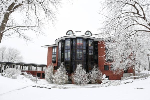 Lucy Scribner Library at Skidmore College surrounded by snow-covered trees and walkways on a winter day.