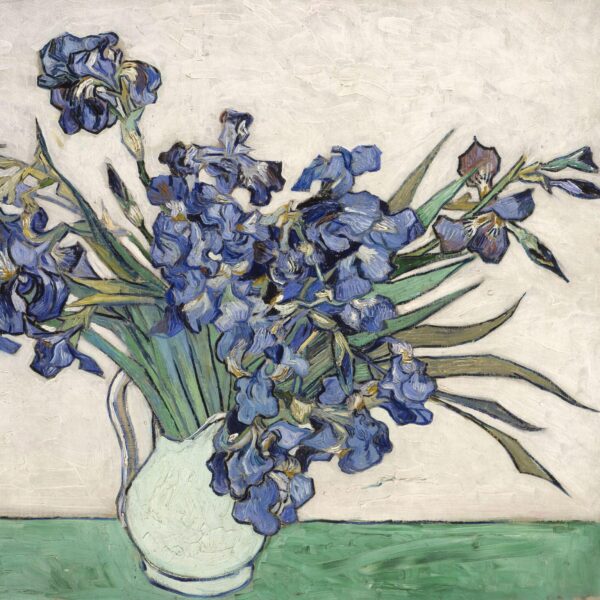 A vase of deep blue irises with long green leaves, painted in Vincent van Gogh’s textured, expressive style, set against a light background and resting on a green tabletop.