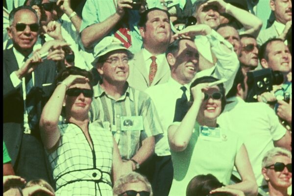 Several audience members watching the Apollo space launch.