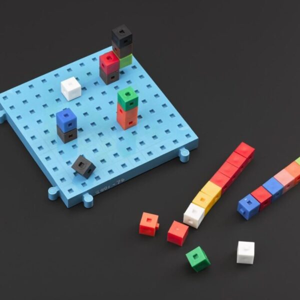 Colorful interlocking cube blocks arranged on a light blue pegboard and in small stacks nearby, demonstrating counting or math concepts with modular “centicube” pieces.