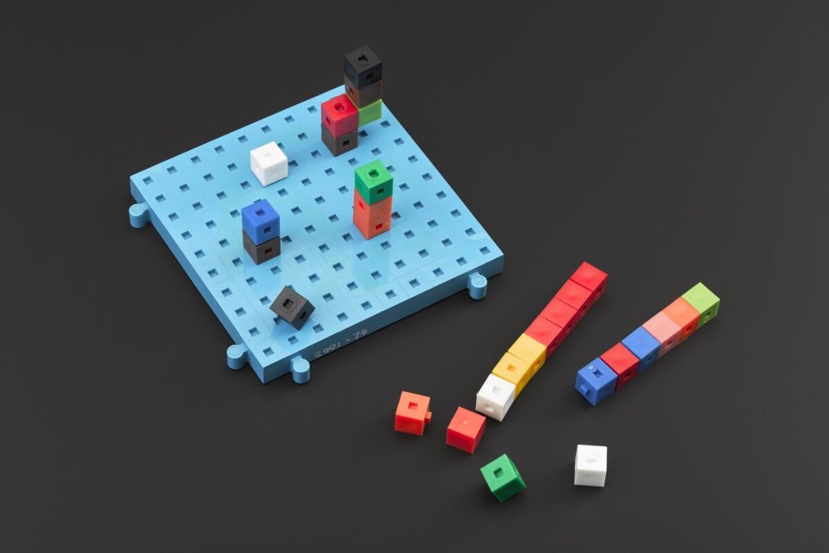 Colorful interlocking cube blocks arranged on a light blue pegboard and in small stacks nearby, demonstrating counting or math concepts with modular “centicube” pieces.
