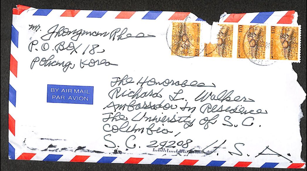 Hand-addressed airmail envelope with postage stamps and postal markings.