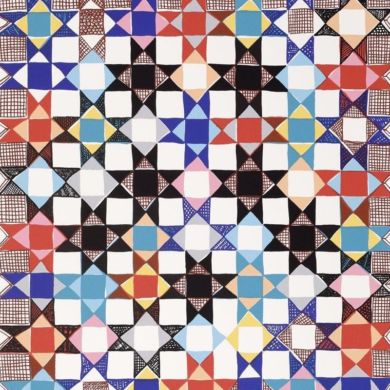 Colorful geometric print featuring a repeating star pattern in red, blue, black, yellow, pink, and white, arranged in a quilt-like grid.