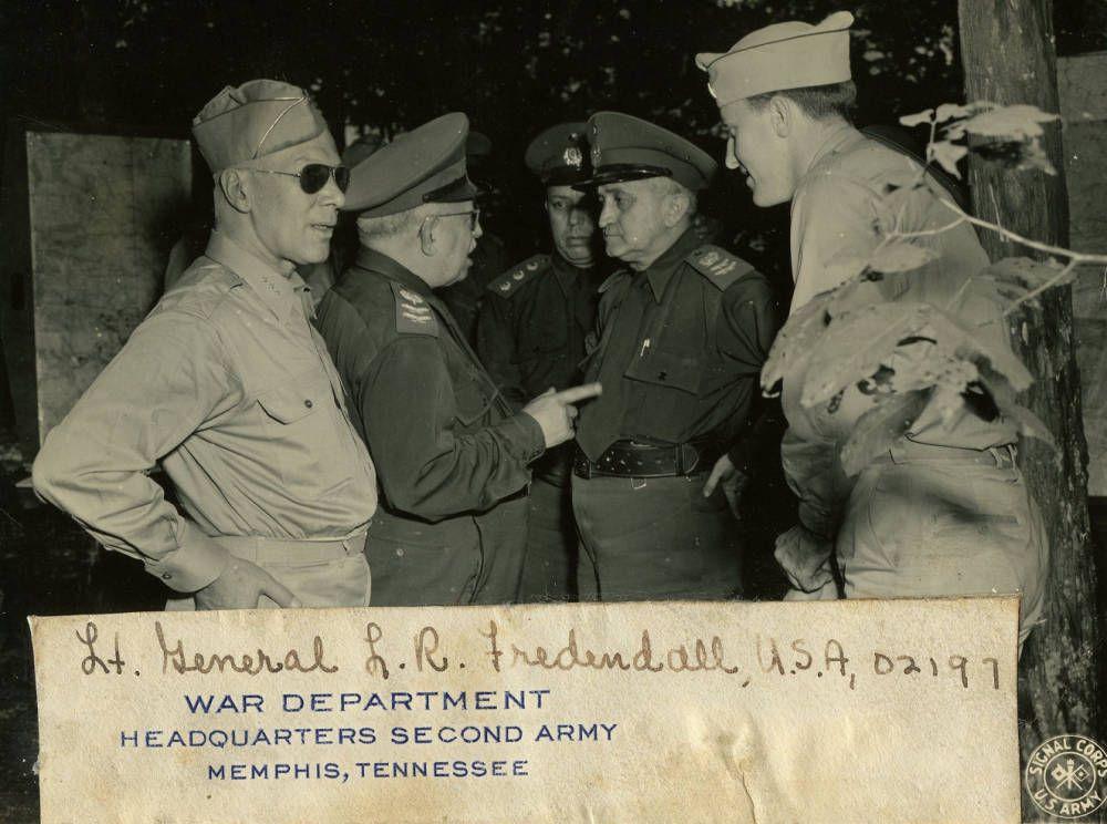 Black-and-white photograph of four uniformed military officers talking outdoors. A caption identifies Lt. Gen. L. R. Fredendall.